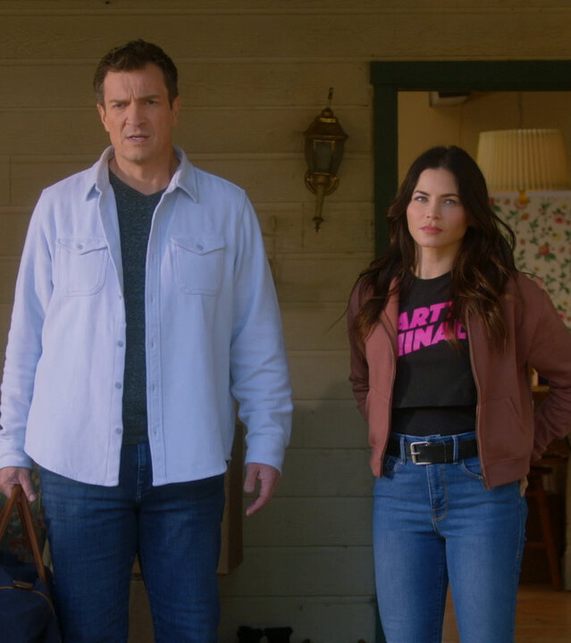 "The Rookie - Die Falle": John Nolan (Nathan Fillion) und Bailey (Jenna Dewan) stehen auf der Veranda des Hauses und betrachten ihre Besucher skeptisch.
