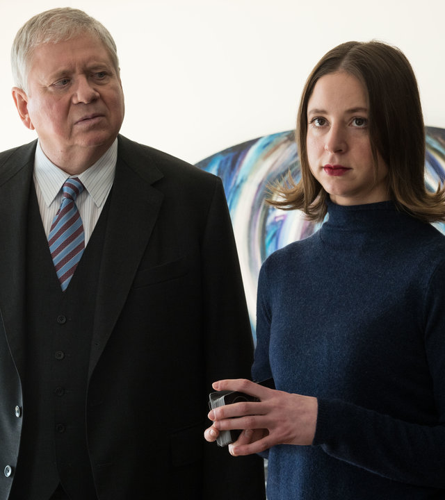 "Der Staatsanwalt – Die Macht der Sterne": Bernd Reuther (Rainer Hunold) und Tabea Thau (Sandra von Ruffin) stehen nebeneinander in einem Zimmer. Reuther blickt Tabea skeptisch an. Diese hält einen Stapel Karten in den Händen und schaut starr nach vorne.