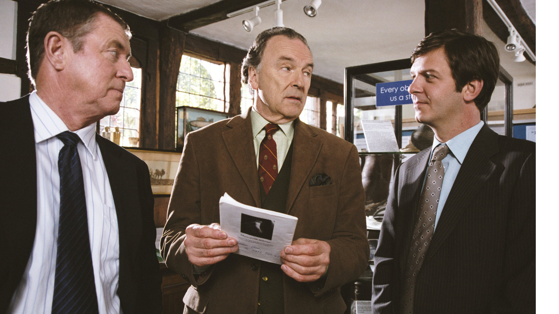 "Inspector Barnaby - Fluch über Winyard": Barnaby (John Nettles) und sein Assistent Jones (Jason Hughes) stehen zusammen mit dem Heimatmuseumsdirektor Giles Cato (Michael Elwyn) und unterhalten sich.