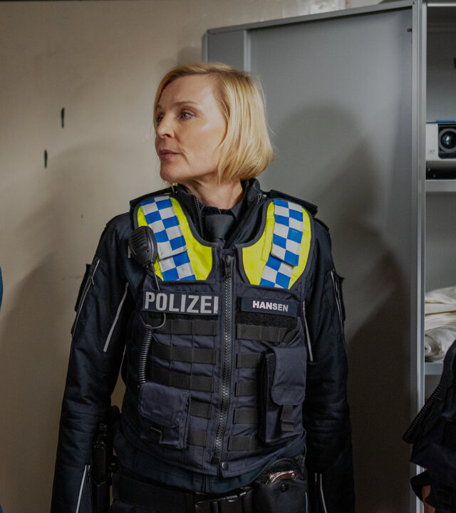 "Notruf Hafenkante - Ehrenwertes Haus": Die Polizistin Melanie Hansen (Sanna Englund) und ihr Kollege Mattes Seeler (Matthias Schloo) stehen mit Marvin (Mateo Wansing Lorrio) in einem Kellerraum. Beide schauen ihn ernst an.