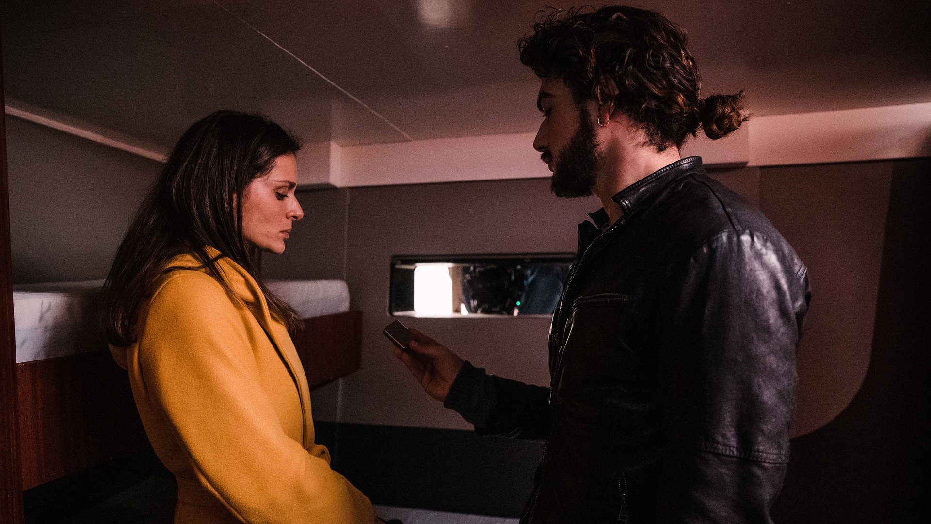 "Survivors - Mörder": Lorenzo (Giacomo Giorgio) steht Paola (Raffaella Rea) in ihrer Kabine auf dem Segelschiff gegenüber. Er sieht sie intensiv an, während sie unsicher nach unten blickt.
