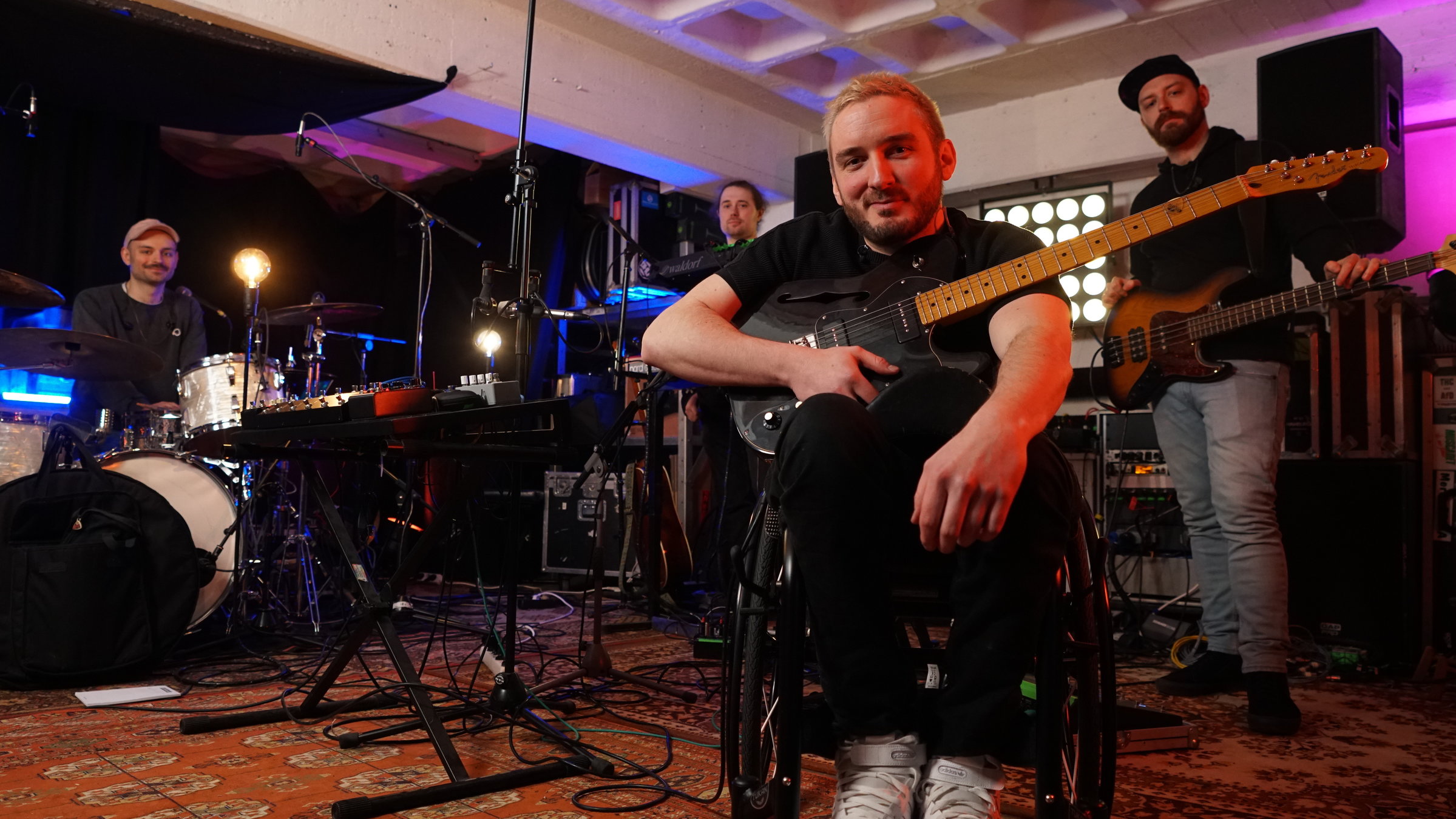 "Einfach Mensch! - Spielend Barrieren überwinden?": Felix Brückner, mit Gitarre im Arm, mit seinen Bandkollegen im Proberaum.