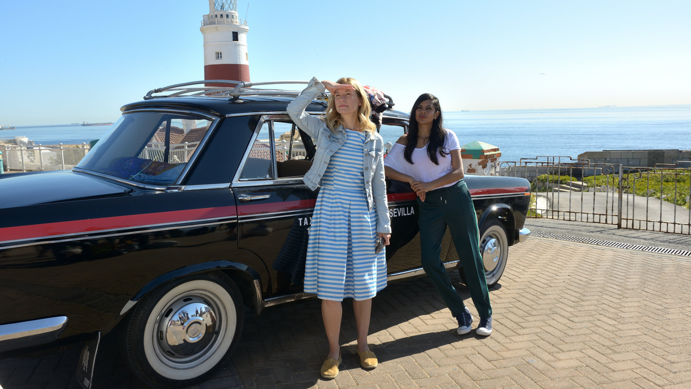 "Ein Sommer in Andalusien": Draußen, vorm Leuchtturm stehen Pia (Birte Hanusrichter) und Flora (Collien Ulmen-Fernandes) neben einem Taxi und schauen in eine Richtung.