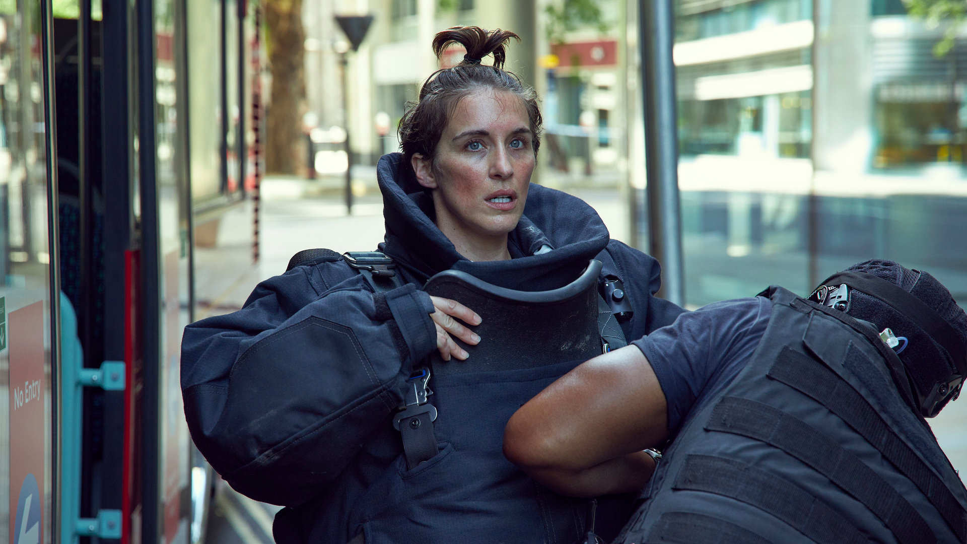"Trigger Point - Verdacht": Lana (Vicky McClure) steht in voller Schutzmontur angespannt auf der Straße. Danny (Eric Shango) steht vor ihr und hilft ihr beim Schließen der Schutzweste.