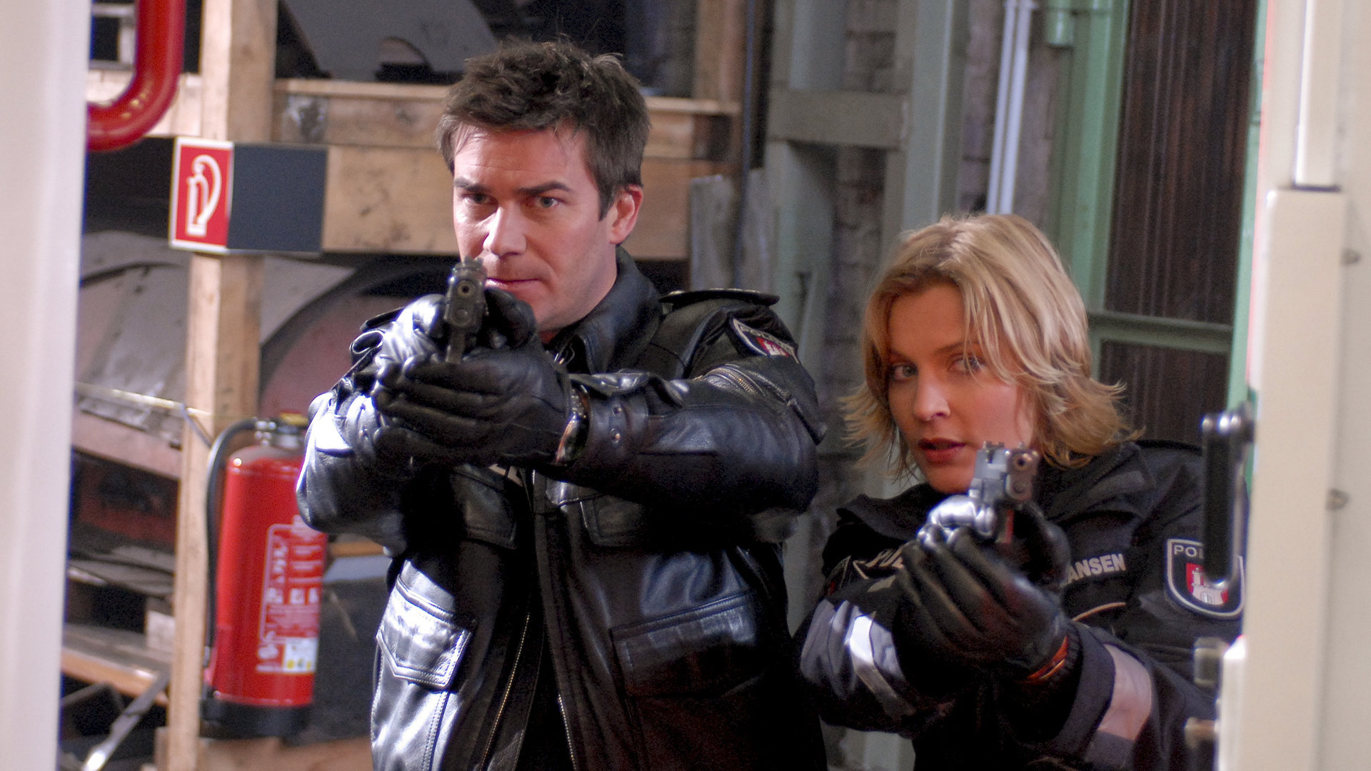 "Notruf Hafenkante - Die Entführung": Nils (Thomas Scharff) und Melanie (Sanna Englund) stehen nebeneinander mit gezogenen Waffen.