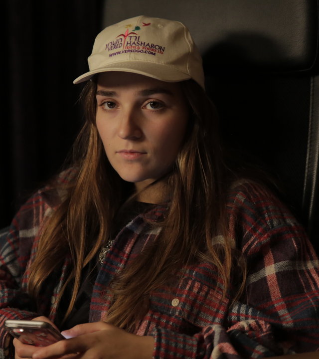 "About Saturday - Swipe der Woche": Klara (Darin Hagi) sitzt in einem dunklen Tonstudio und schaut gedankenvertieft in die Ferne, während sie ein Handy in den Händen hält.