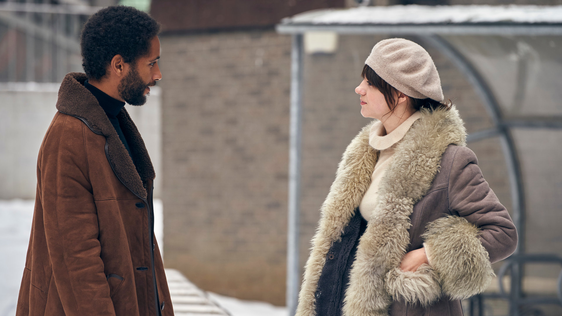"Normal People - Toxisch": Marianne (Daisy Edgar-Jones) steht Lukas (Lancelot Ncube) draußen vor einer Bushaltestelle in dicken Winterklamotten gegenüber und schaut ihn an.