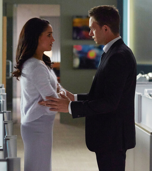 "Suits - Mehr als ein hübsches Gesicht": Rachel (Meghan Markle) und Mike (Patrick J. Adams) stehen sich in einem Großraumbüro gegenüber. Rachel hat ihre Arme verschränkt. Mike wiederum hat seine Hände auf Rachels Ellenbogen gelegt und redet auf sie ein.