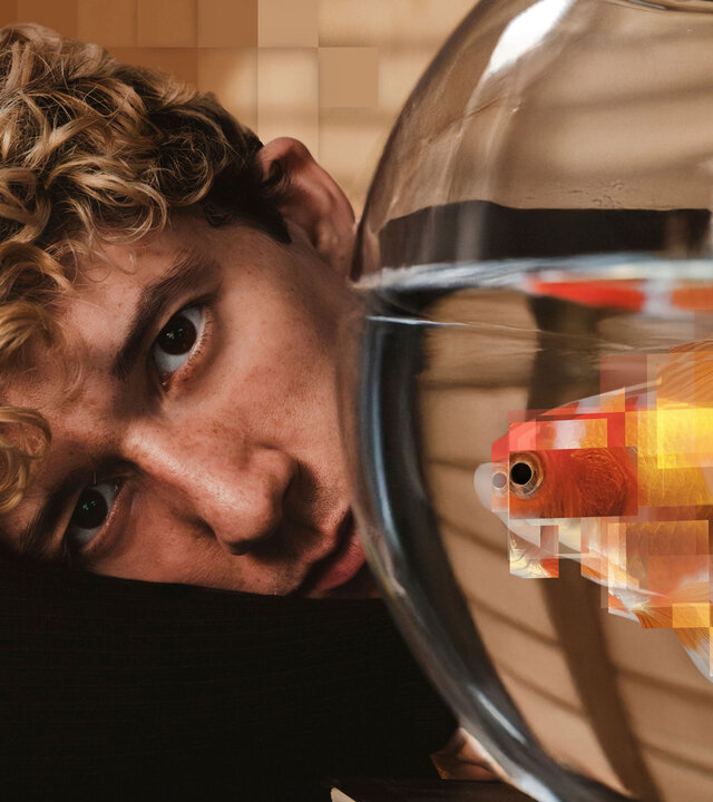 "WTF is Jule?! - Die perfekte Illusion": Maximilian Mundt hat den Kopf auf seinem Arm gelegt und blickt neben einem Fischglas hervor.