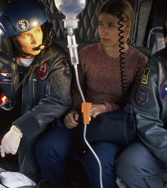 "Die Rettungsflieger - Afrikanisches Fieber": Auf dem Boden des Rettungshubschraubers liegt ein fiebriger Mann auf einer Trage. Davor auf der Sitzbank sitzen dessen Freundin Anne (Kerstin Draeger), Ilona (Julia Heinemann) und Thomas (Ulrich Bähnk).
