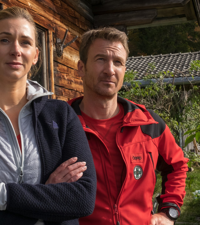 "Der Bergdoktor: Atemlos": Linn (Andrea Gerhard) und Hans (Heiko Ruprecht) stehen nebeneinander vor einer Hütte und blicken in die Ferne.