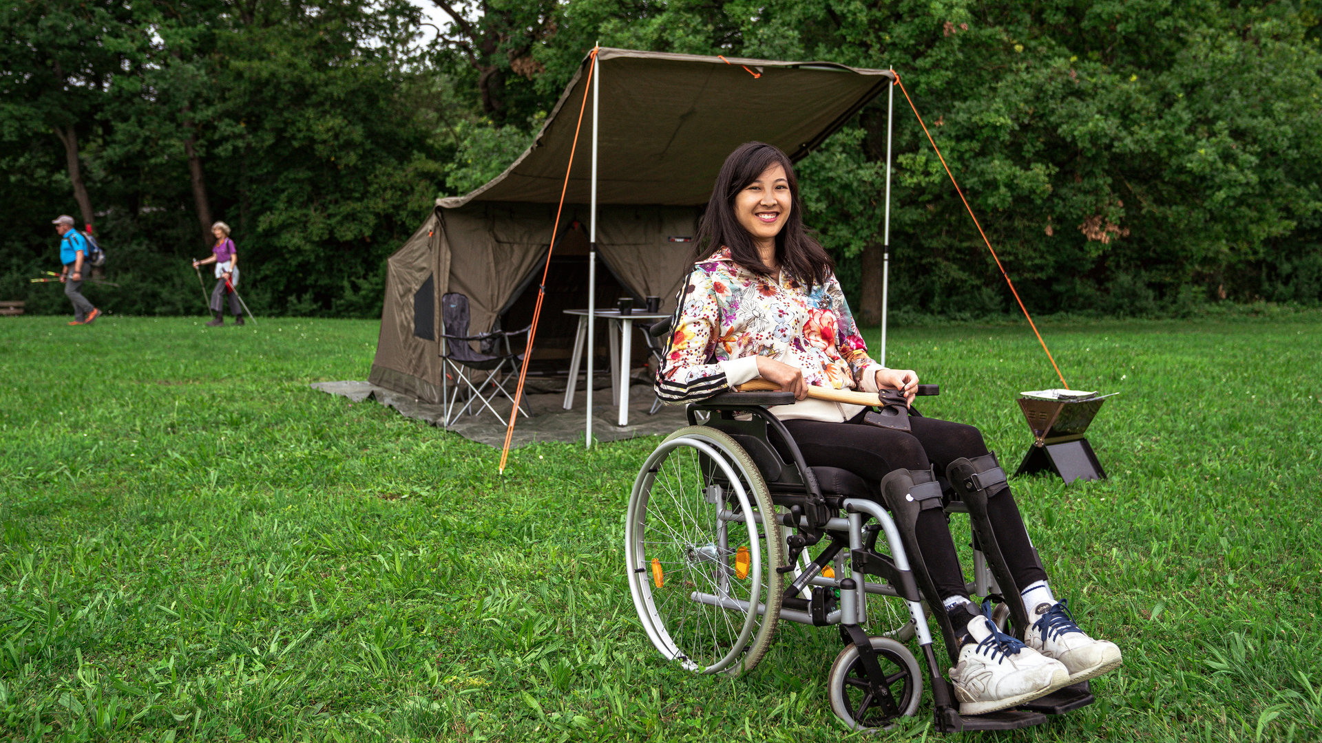 "einfach Mensch": Protagonistin Simone Lai vor einem olivgrünen Zelt mit ausgeklapptem Vordach im Grünen