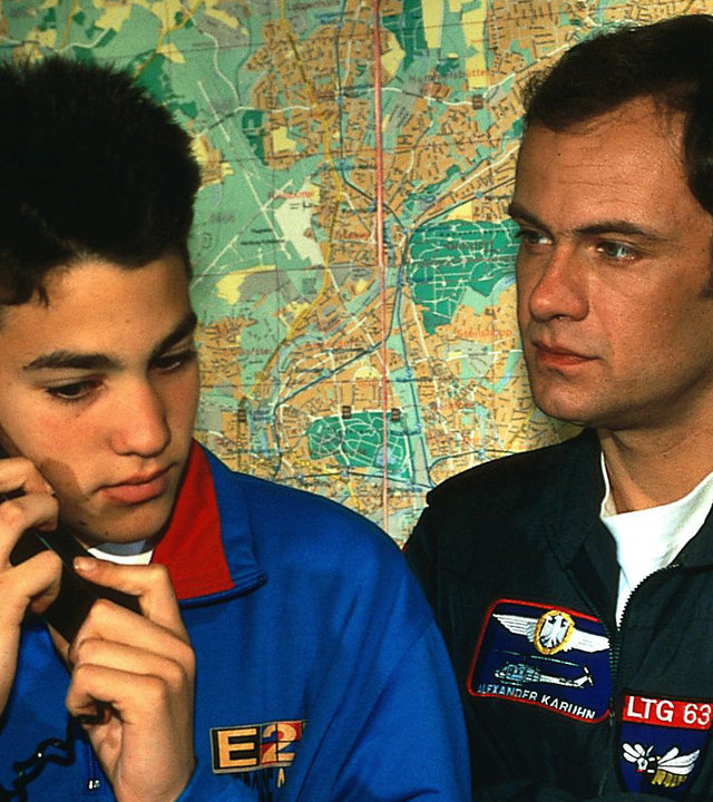 "Die Rettungsflieger - Blindflug": Benny (Pierre Britz) telefoniert, neben ihm steht Alex (Matthias Leja), an der Wand eine Landkarte.