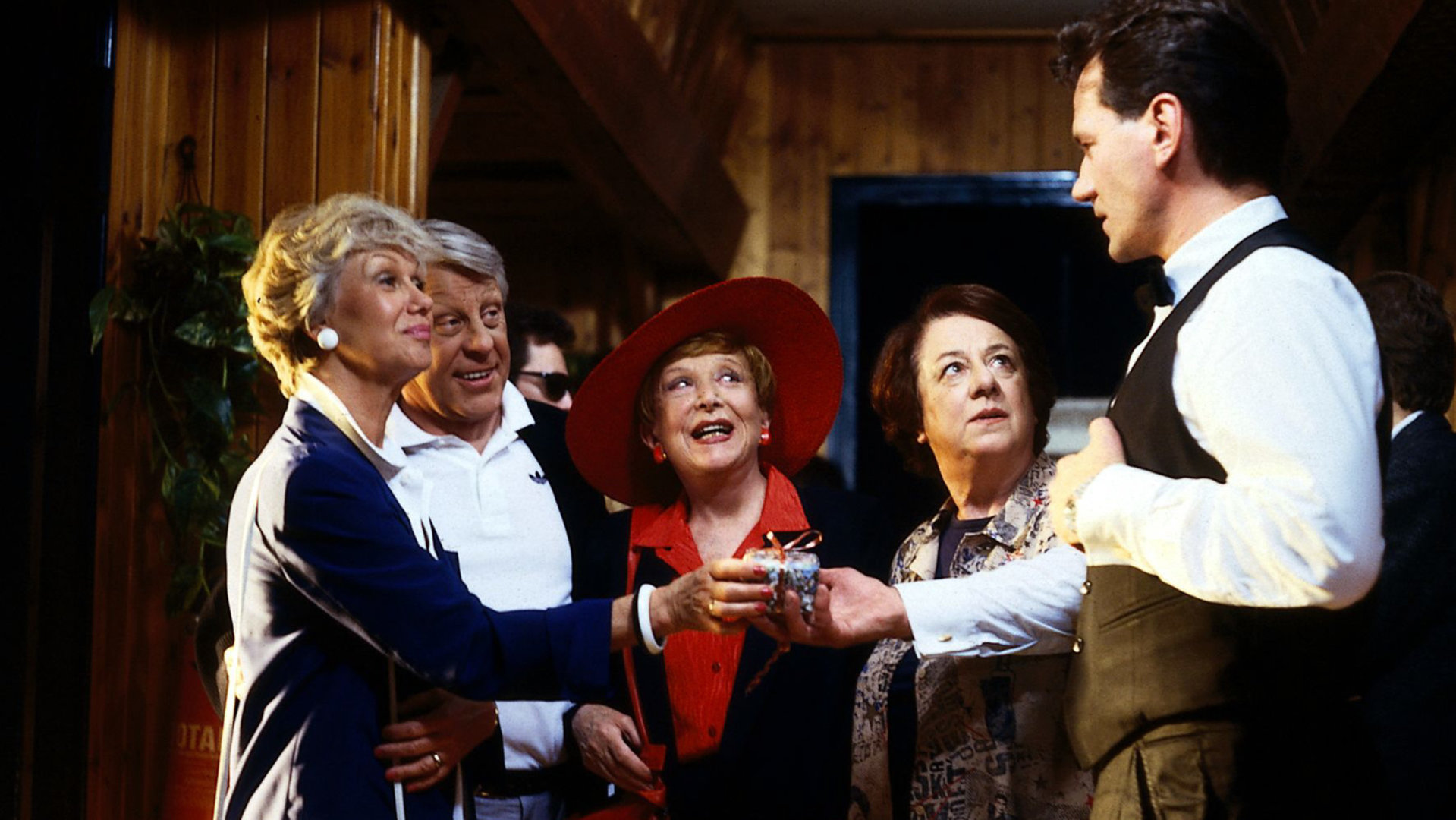 "Die Wicherts von nebenan: Ein Hund für Hannelore": Hannelore (Maria Sebaldt), Eberhard (Stephan Orlac), Oma Käthe (Edith Schollwer) und Gerda (Inge Wolffberg) stehen nebeneinander und blicken zu Kuttlick (Manfred Lehmann, r.), der Hannelore etwas reicht.