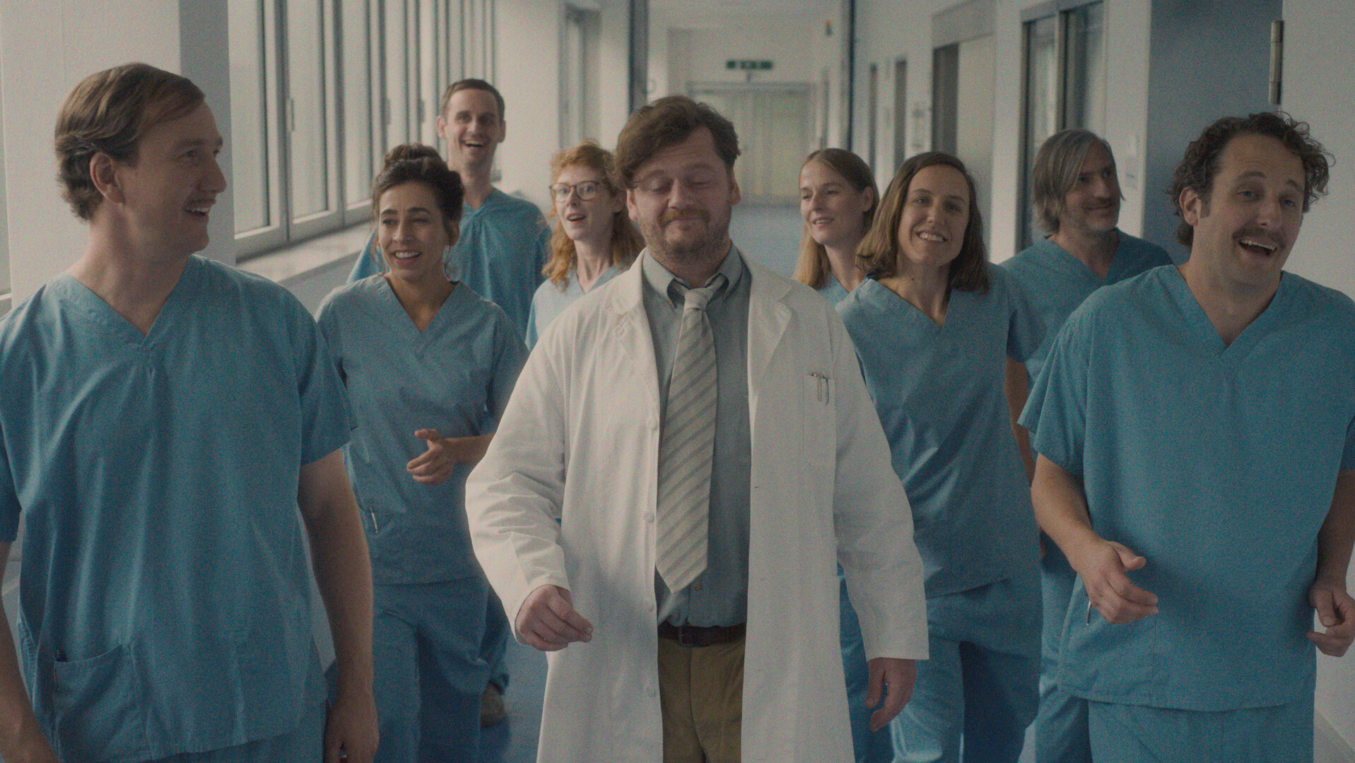 "Das Manko - Schönen Tag noch , ihr Lachse!": Das Manko läuft in Klinikklamotten durch die Station: Romantik Manko (Jan Krauter), Horror Manko (Carol Schuler), Perplex Manko (Sebastian Grünewald), Panik Manko (Sarah Bauerett), Wichtig Manko (David Simon), Mauerblümchen Manko (Julia Schubert), Bienchen Manko (Annika Meier), Dumm Manko (Jonas Hien), Gute Laune Manko (Bastian Reiber). Alle schauen freudig oder lachend nach vorn.
