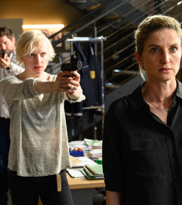 „SOKO Stuttgart - Der Pechvogel“: Luisa Kämmerlein (Anne Müller) bedroht Katja Weidemann (Elisabeth vom Koch) im Großraubüro des Präsidiums mit einer Waffe. Michael Kaiser (Karl Kranzkowski) und Jo Stoll (Peter Ketnath) kommen ihrer Kollegin zu Hilfe: Jo Stoll zielt mit seiner Waffe auf Luisa Kämmerlein, während Michael Kaiser auf sie einredet.