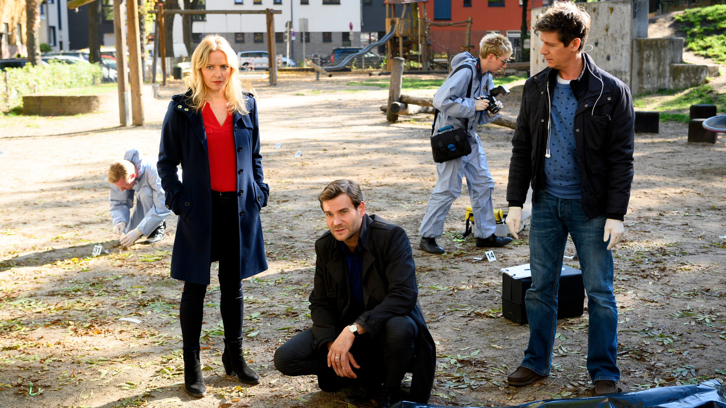 „SOKO Köln – Endstation Sehnsucht“: Anna Maiwald (Diana Staehly), Jonas Fischer (Lukas Piloty), Dr. Kraft (Thomas Clemens) und seine Kollegen von der Spurensicherung (Komparsen) inspizieren den eventuellen Tatort: einen Spielplatz in der Kölner Innenstadt.