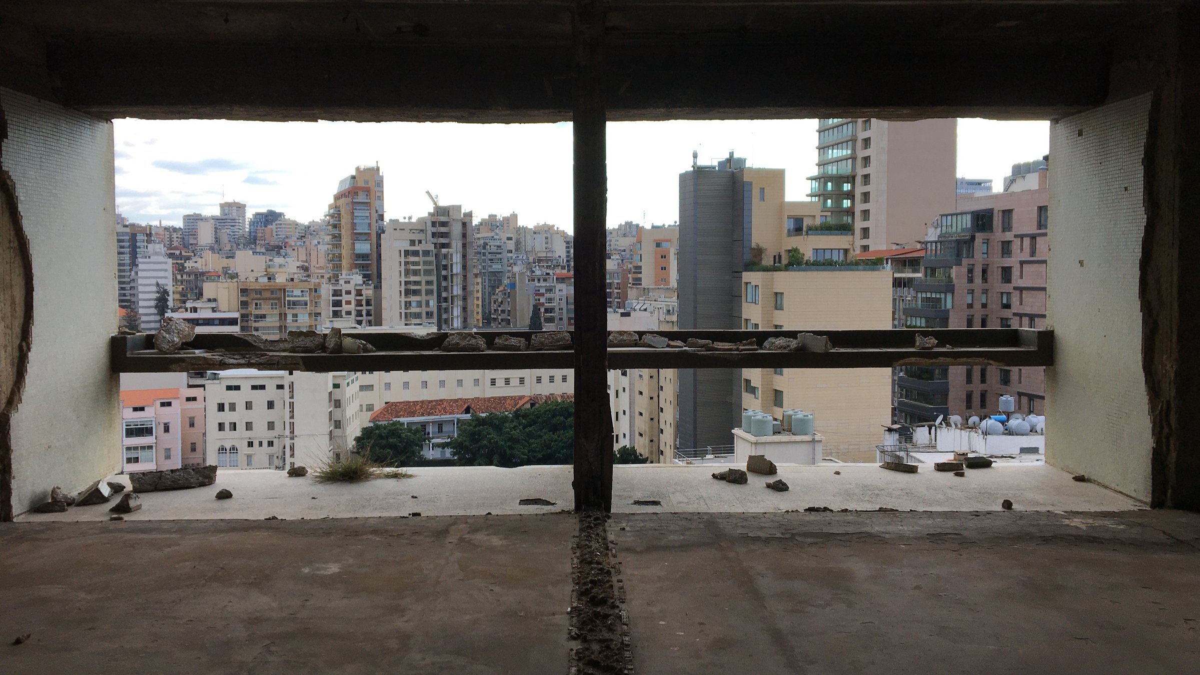 "Die letzten Tage von Beirut": Blick aus einem zerstörten Fenster auf die Skyline von Beirut.