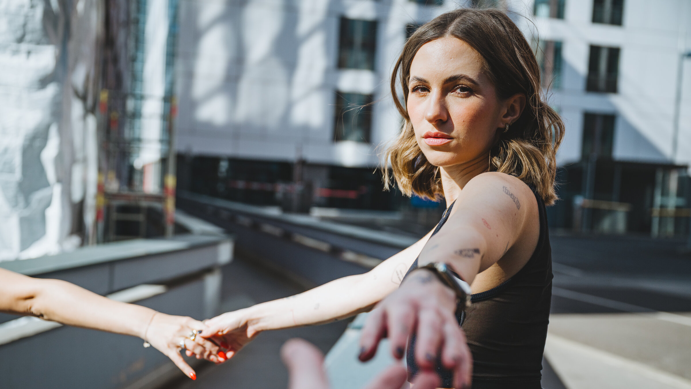 "37°Leben - Neustart nach Trennung": Lorena, eine junge Frau, blickt in die Kamera. Von dort streckt ein Mann die Hand nach ihr aus, während ihre rechte Hand von einer Frau gehalten wird.