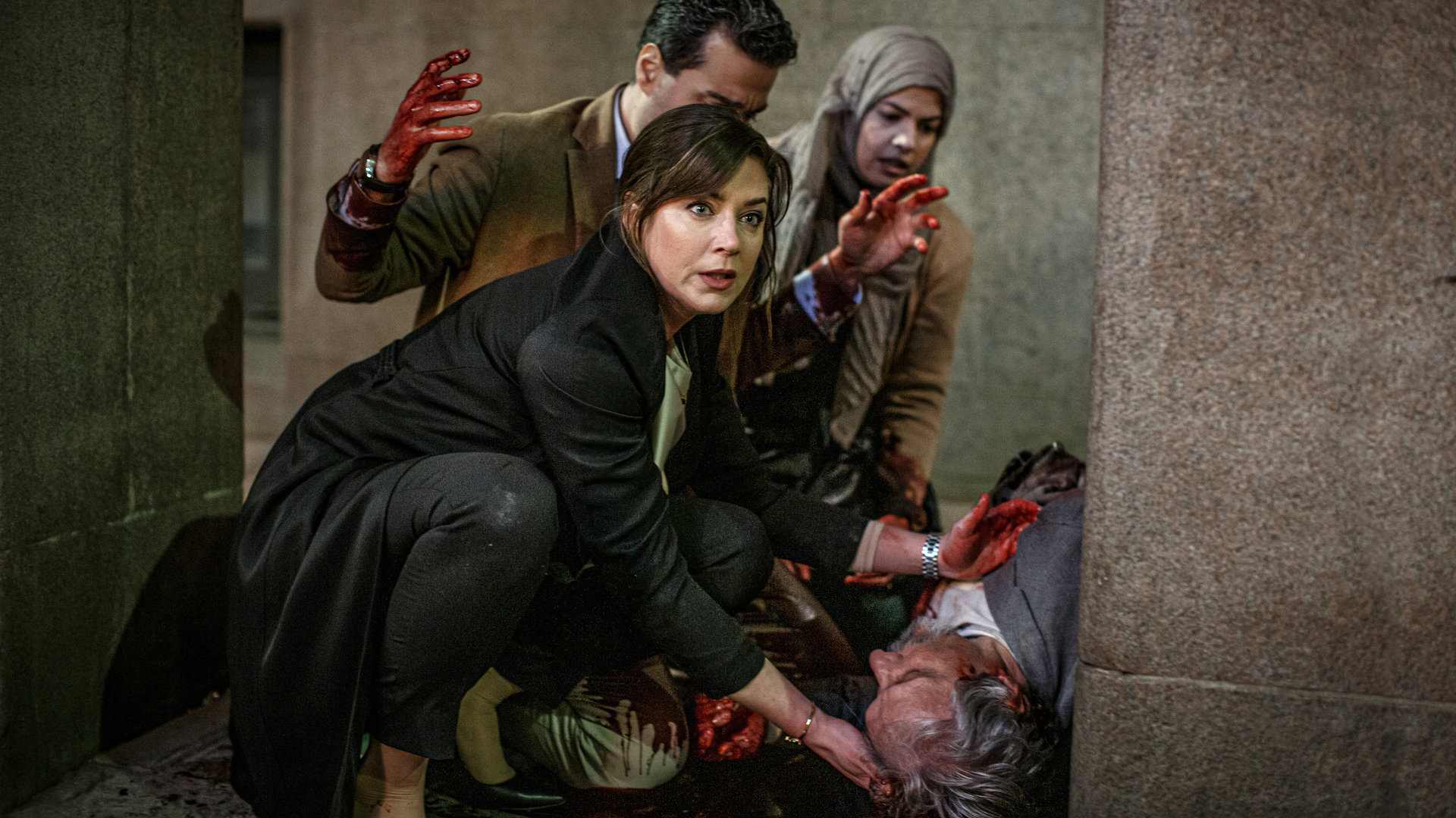 "Kommissar Beck: Tod in Samarra": Panisch versuchen Alexandra Beijer (Jennie Silfverhjelm), Majid (Simon Mezher) und Sana (Noha Mousbah) den am Boden liegenden und verletzten Juanid Hanoush (Saeed Hooshidar) zu helfen. Die Hände von Alexandra und Majid sind voller Blut.