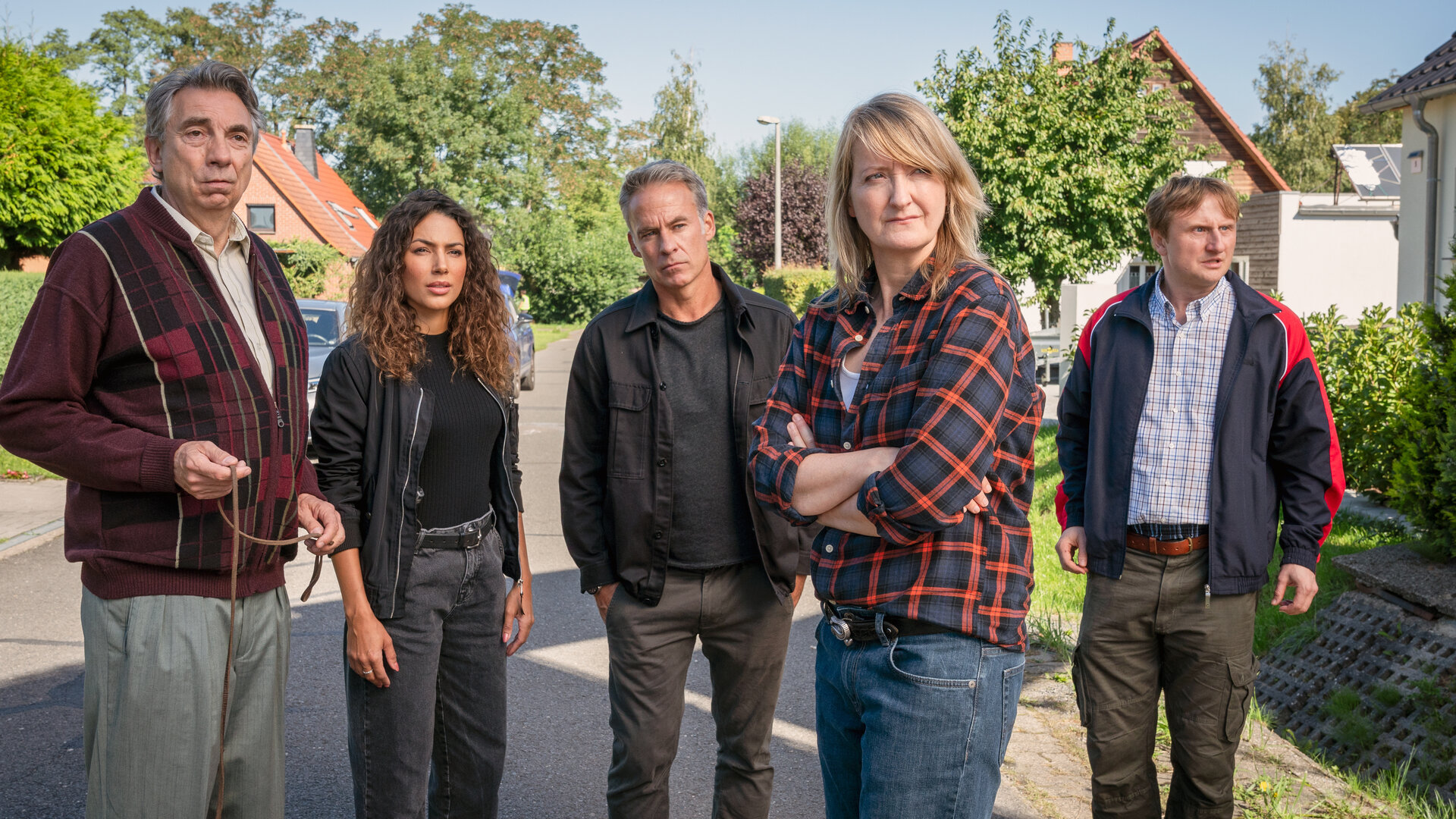 "SOKO Leipzig - Hasch mich": Kim (Amy Mußul), Jan (Marco Girnth), Wolfgang Güntgen (Michael Benthin) und Silke Wegener (Annedore Kleist) stehen in einem gepflegten Wohngebiet auf einer Straße. Jimmy Niehaus (Michael Kranz) steht mit beunruhigtem Blick neben der Gruppe.