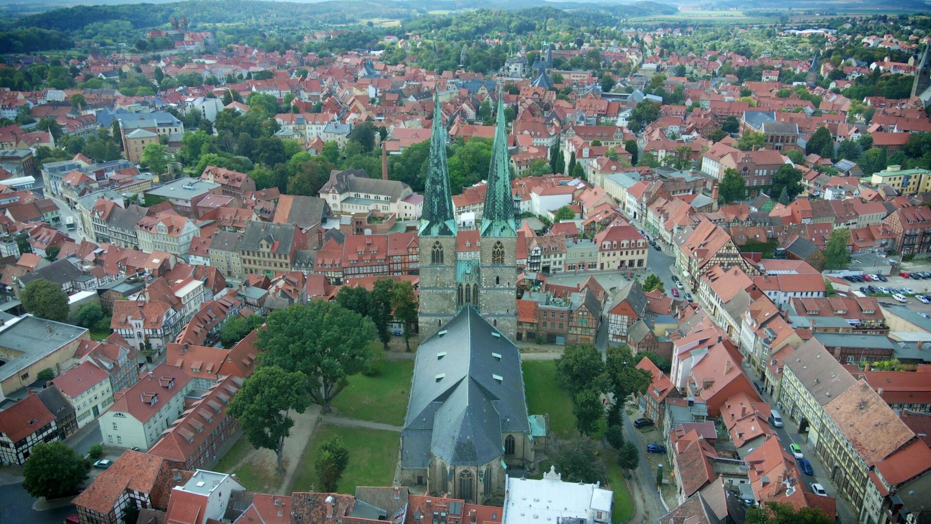 "Evangelischer Gottesdienst - Der andere Blick": Luftbild der evangelischen Kirche St. Nikolai mit ihren beiden schlanken, hoch aufragenden Türmen, die inmitten der Altstadt von Quedlinburg steht.