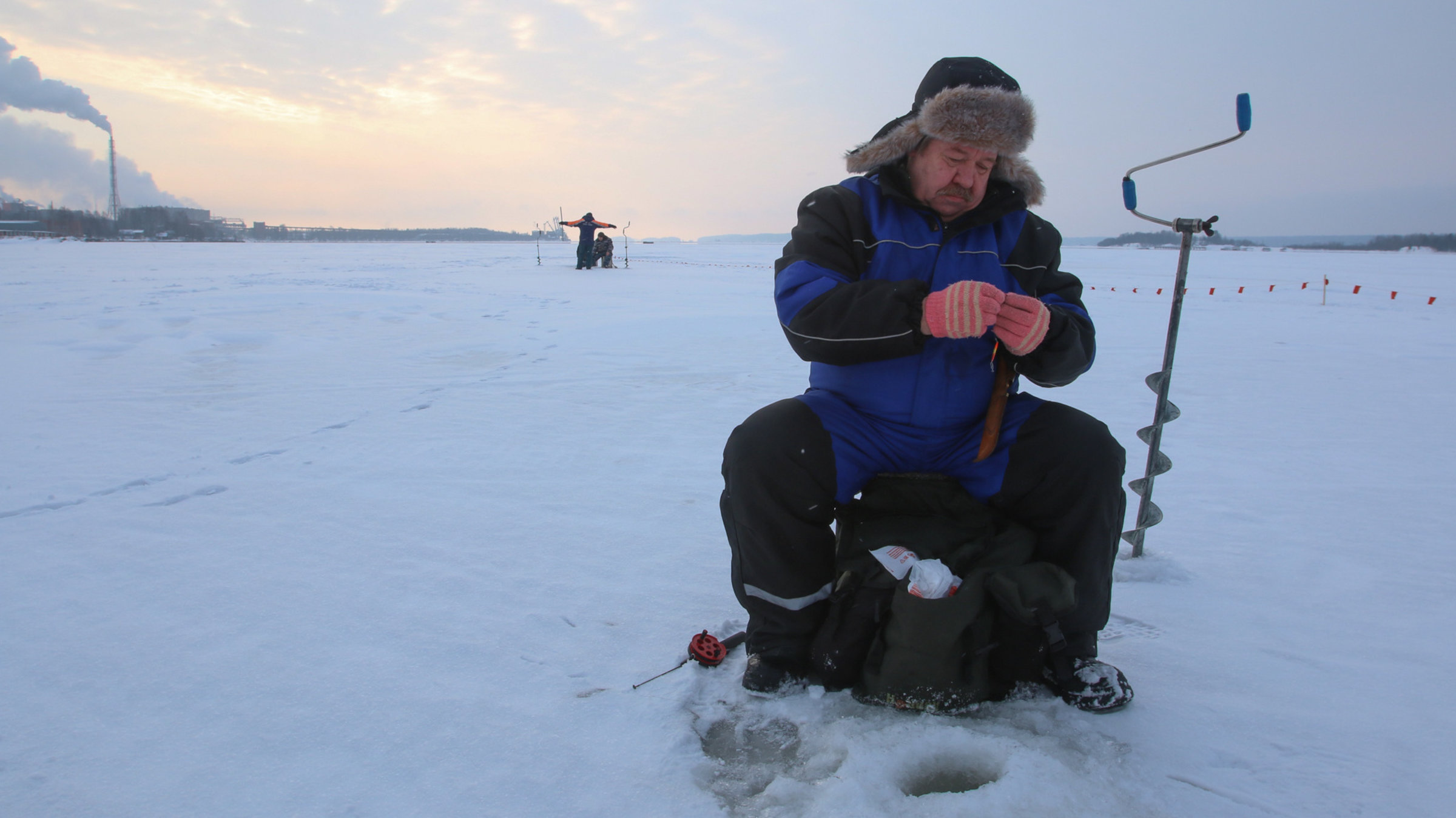 "Let it snow": Ein Mann angelt an einem Eisloch.