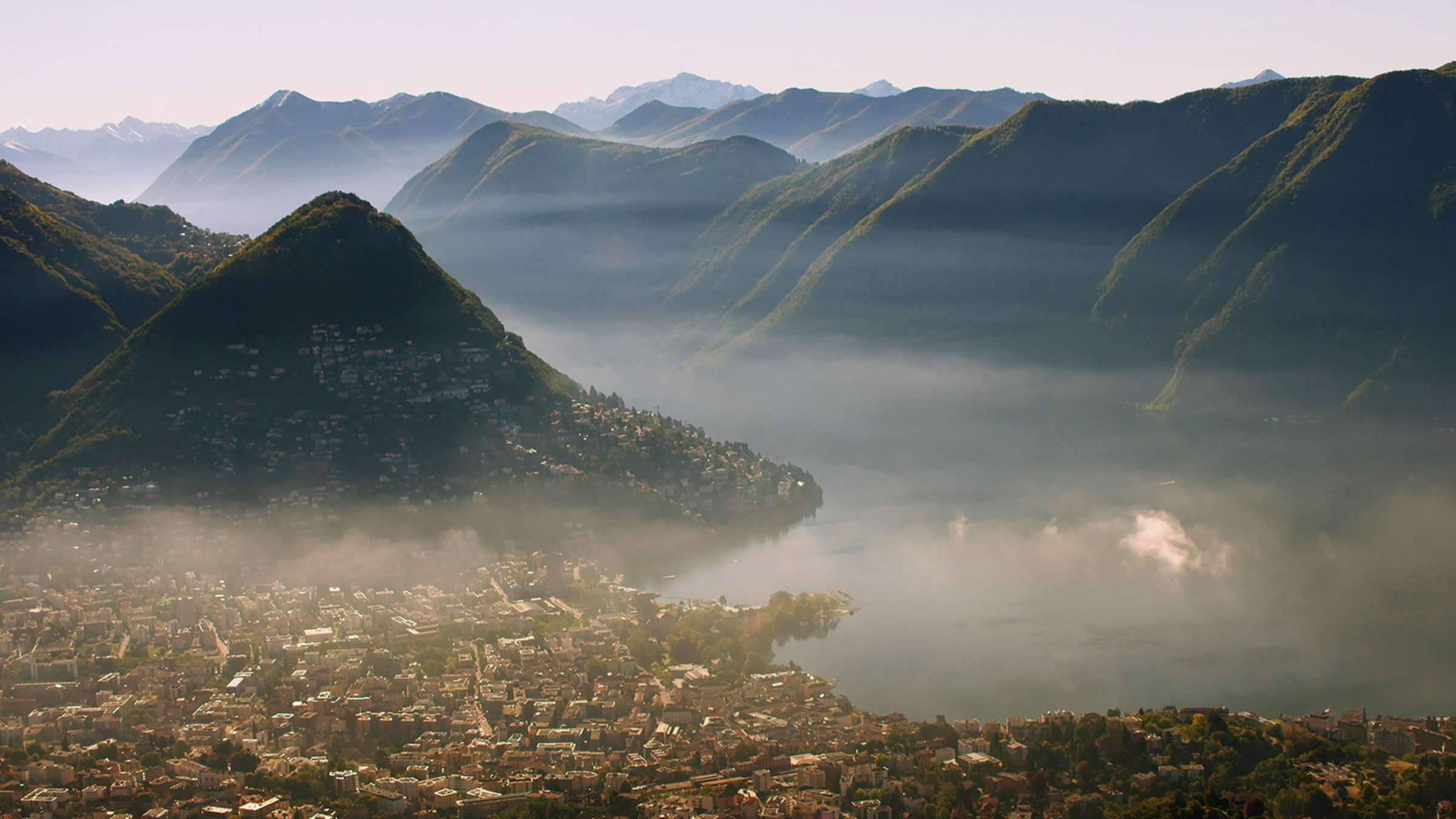 "Jenseits der Alpen - Am Luganer See": Morgendunst hängt über der Tessiner Stadt Lugano.