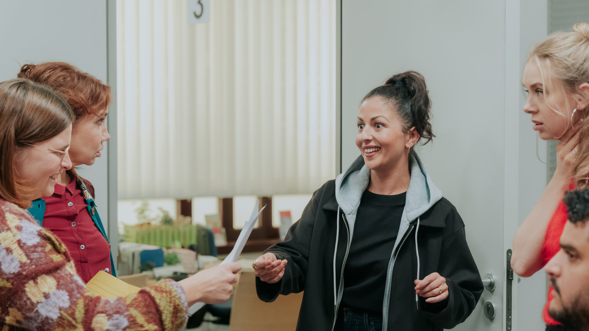 "Nine to Five - Das Amt - Ferienanlage DÃ¶beritz": Conny (Lisa Hrdina), Doris (Kathrin Angerer), Hanni (TÃ¼lin Sezgin), Melissa (Anna Herrmann) und Orkan (Yasin El Harrouk) haben sich in Kreis in einem Innenraum versammelt und reden.