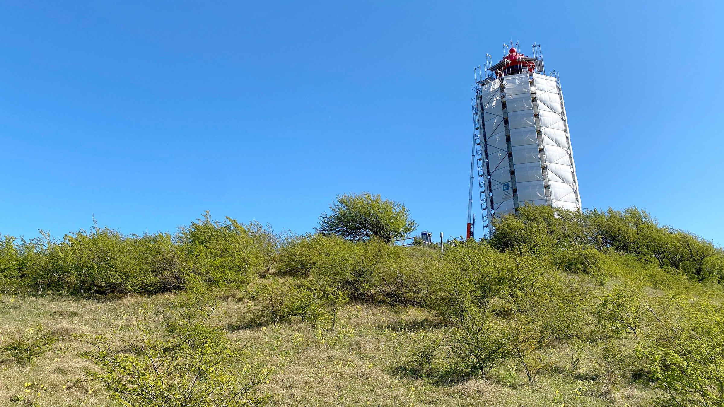 "Die Nordreportage: Eine Insel oben ohne": Der Leuchtturm Dornbusch ist eingerüstet und in ein Sandstrahlnetz verpackt.