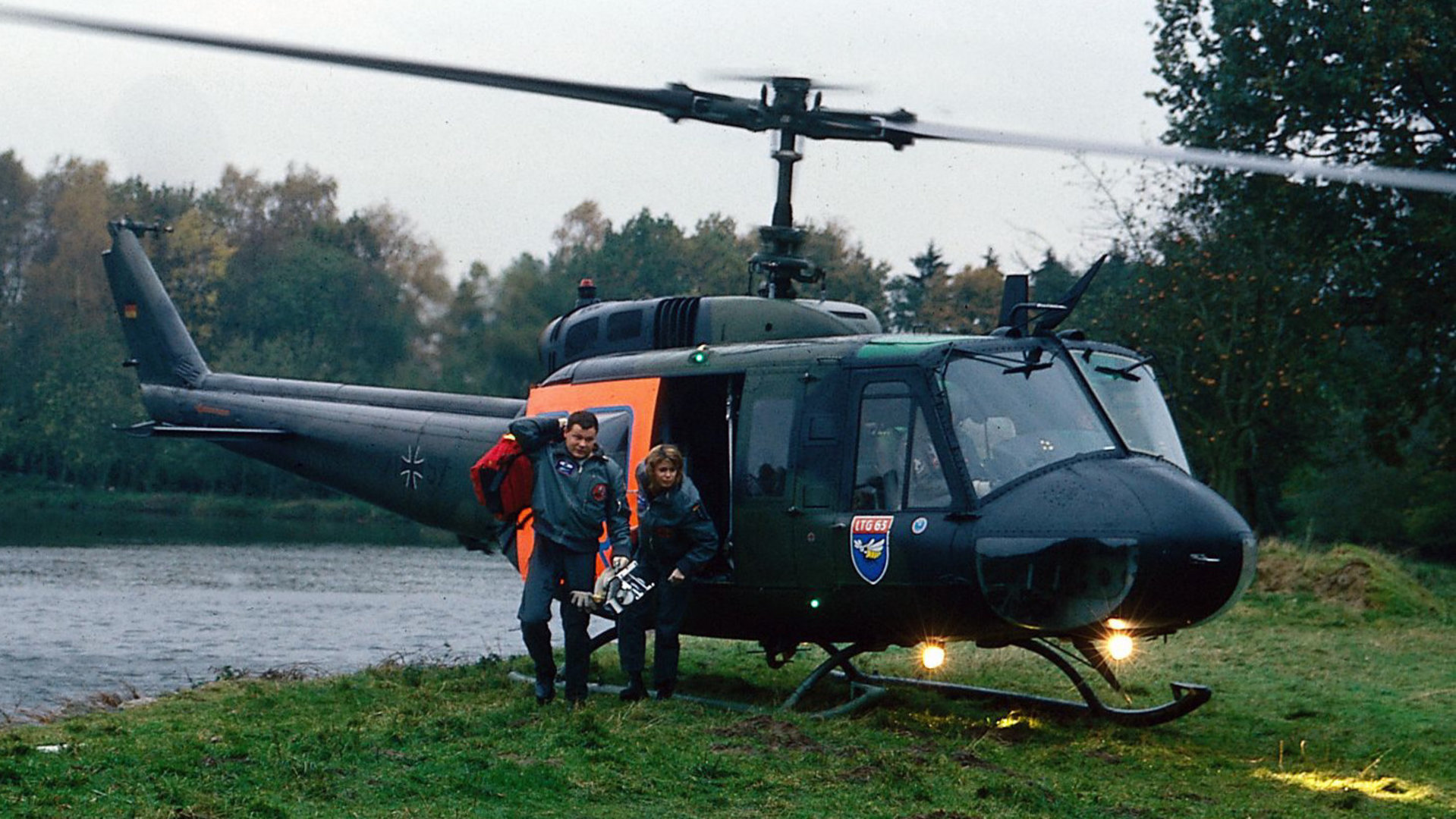 "Die Rettungsflieger - Schreckliche Ohnmacht": Thomas (Ulrich Bähnk) und Maren (Gerit Kling) springen aus dem Rettungshubschrauber, der an einem kleinen See im Wald gelandet ist.