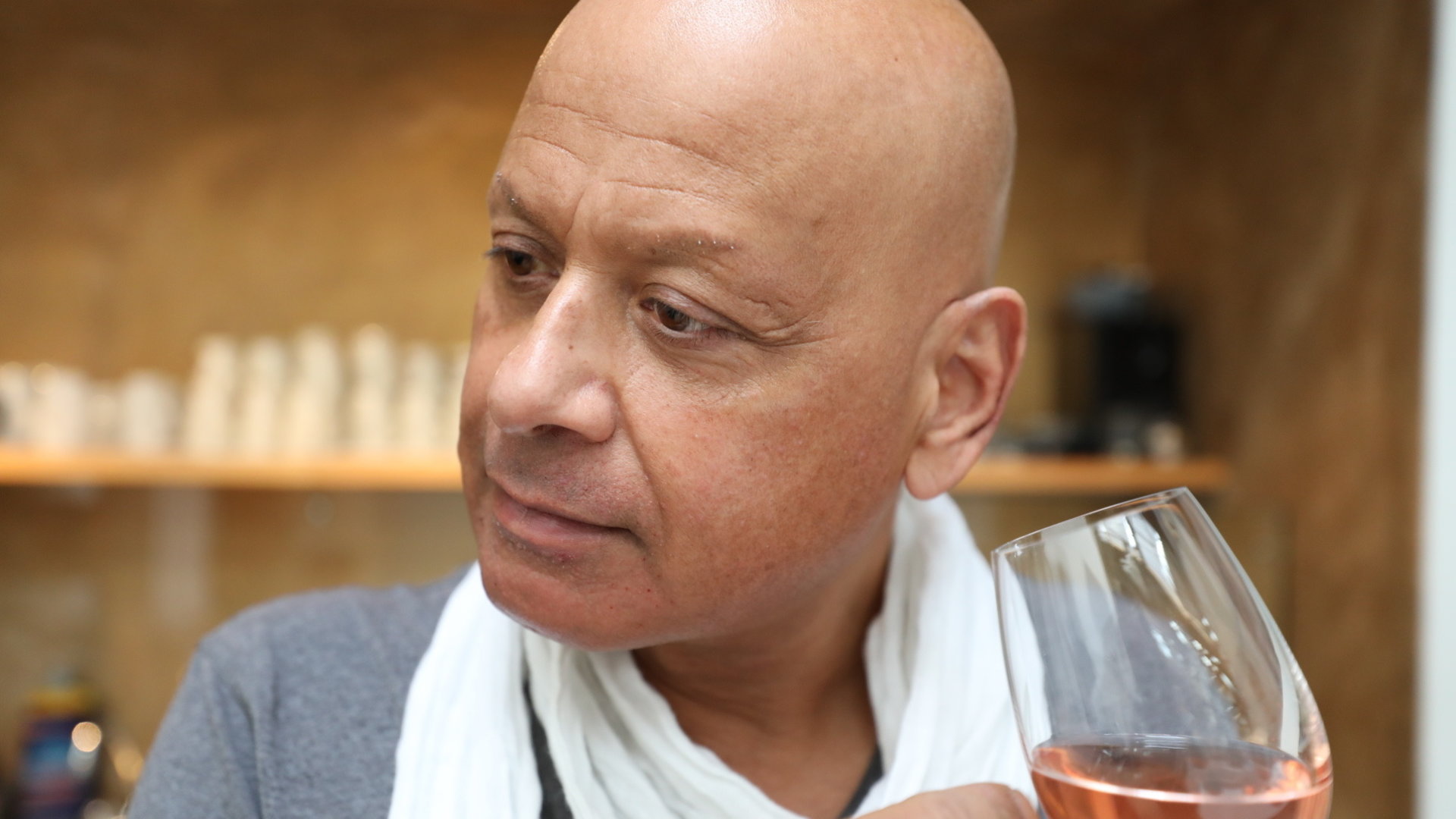 "einfach Mensch – Saliya Kahawatte: "Ich sehe anders!"": Nahaufnahme von Saliya mit einem Glas Rosewein in der Hand.