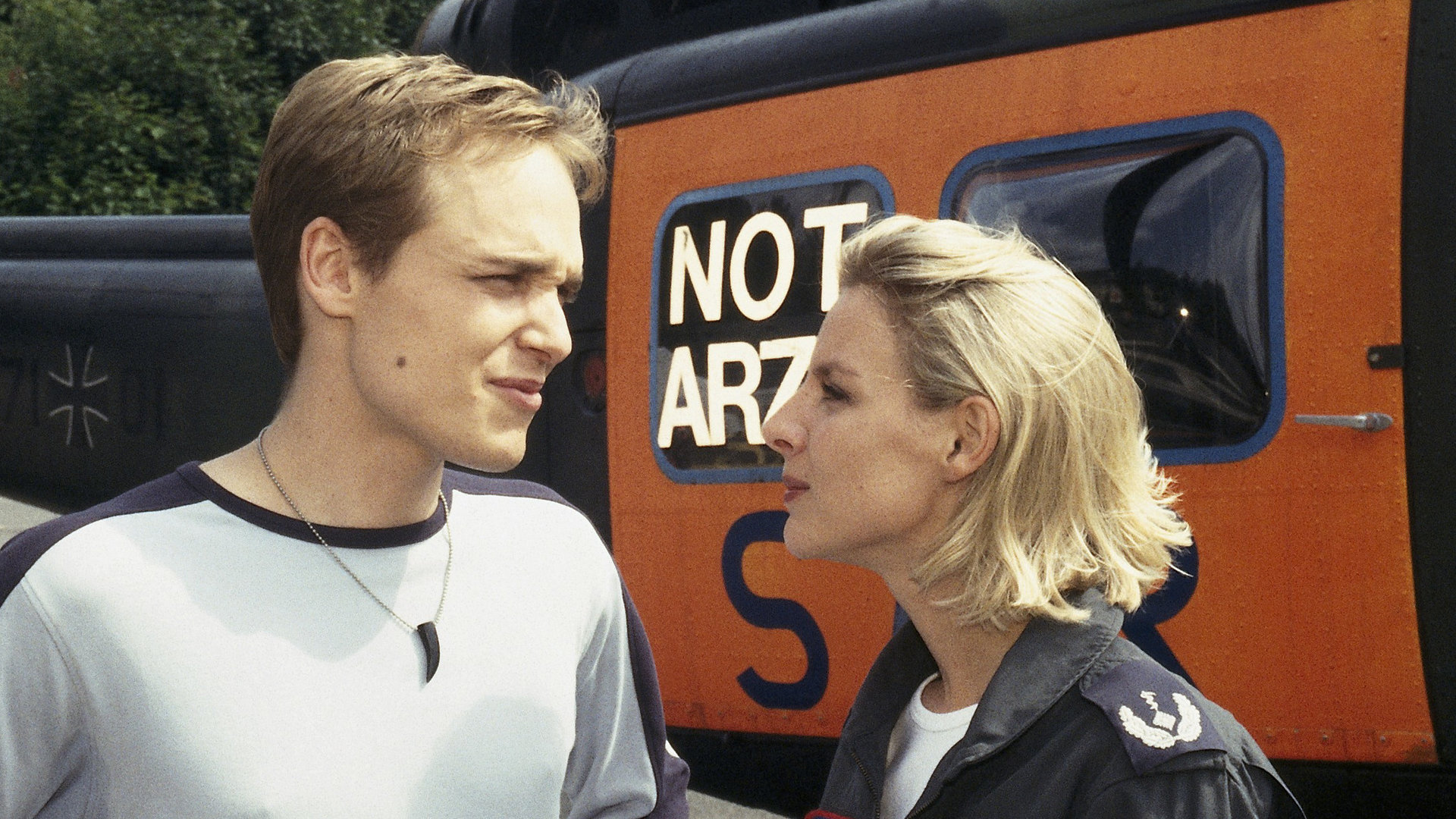 "Die Rettungsflieger - Lauter Katastrophen": Sabine (Marlene Marlow) und ihr Bruder Charlie (Adrian Zwicker) stehen nebeneinander am Hubschrauber und unterhalten sich.