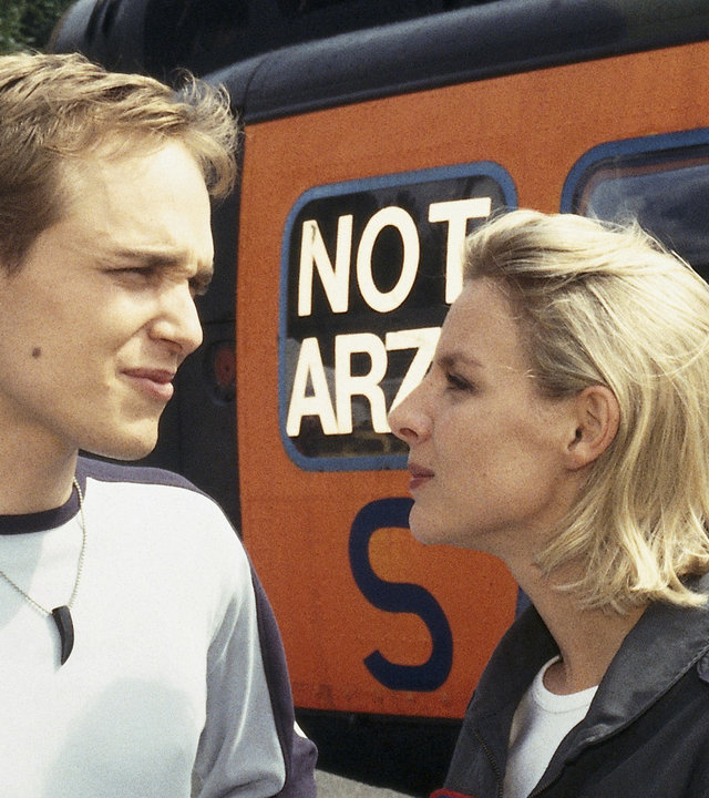 "Die Rettungsflieger - Lauter Katastrophen": Sabine (Marlene Marlow) und ihr Bruder Charlie (Adrian Zwicker) stehen nebeneinander am Hubschrauber und unterhalten sich.