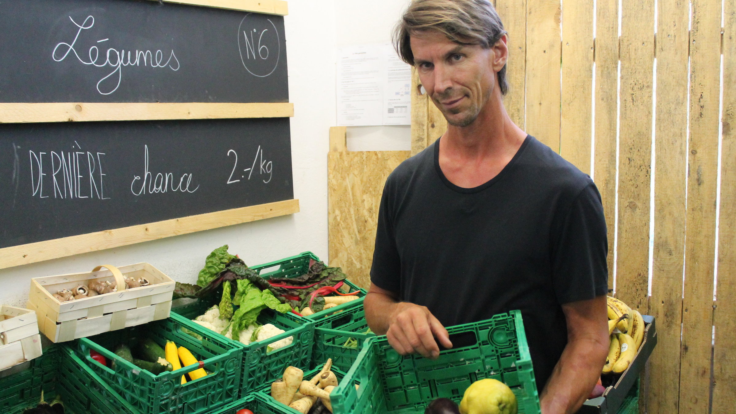 "plan b: Obst ohne Gift - Wenn Natur die Chemie ersetzt": Michael Dusong steht vor Kisten mit Obst und Gemüse und hält eine Obstkiste in den Händen.