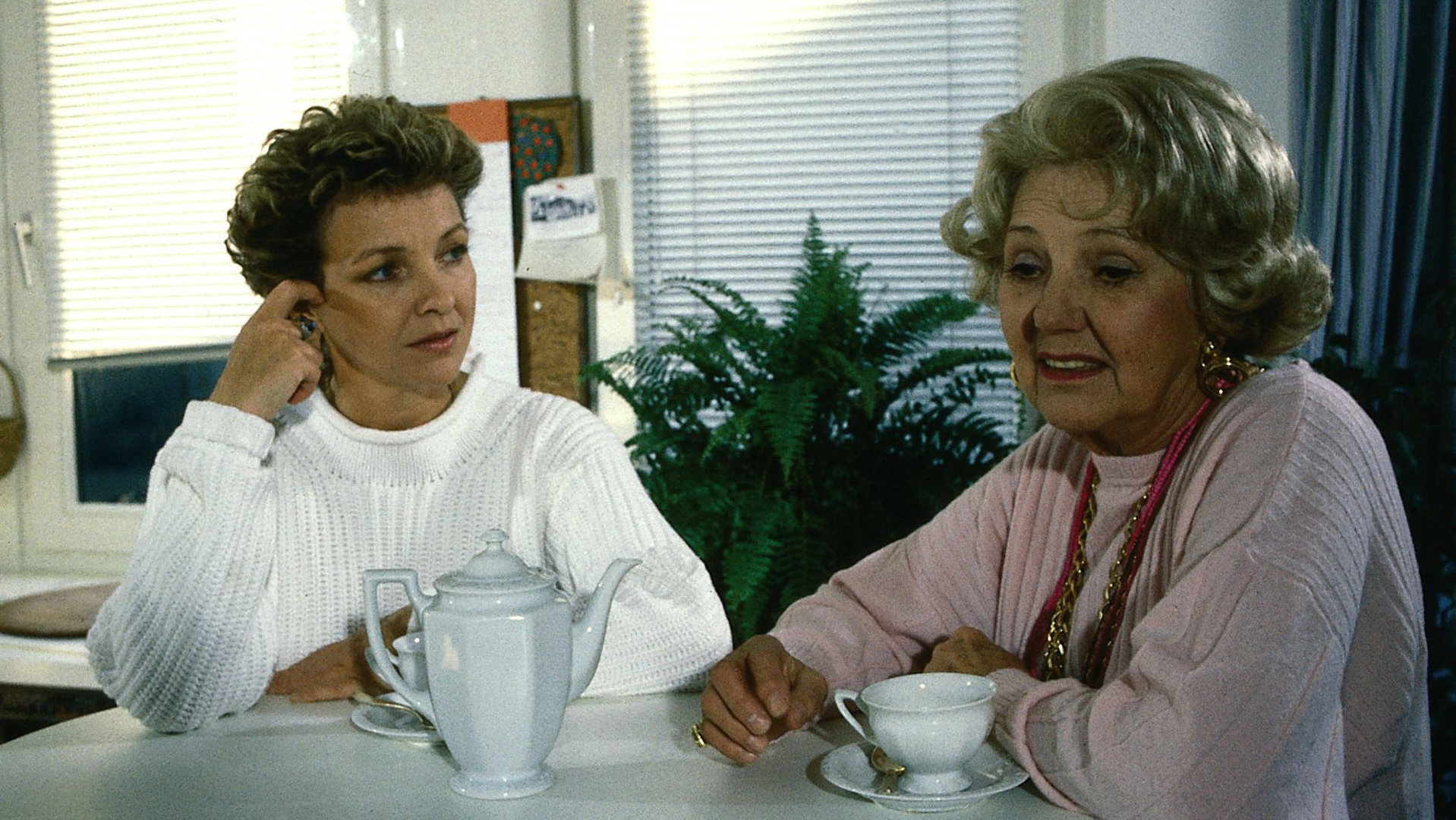 "Der Landarzt - Der Kräuterdoktor": Annemarie (Gila von Weitershausen) und ihre Mutter (Jane Tilden) trinken zusammen eine Tasse Kaffee. Annemarie schaut zu ihrer Mutter, die wiederum unzufrieden ins Leere schaut.