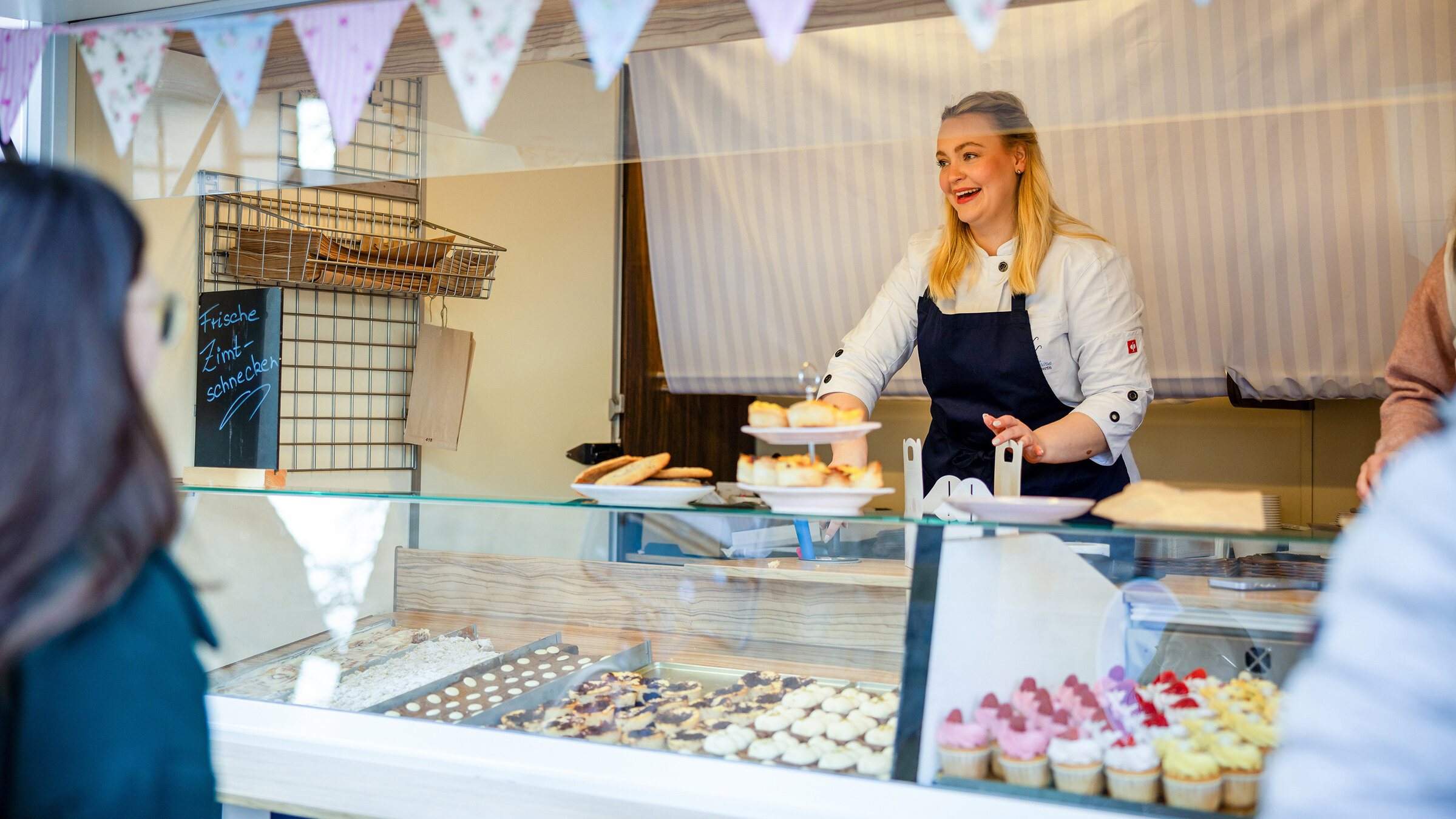 "Die Nordreportage: Zimtschnecken, Cupcakes und Kredit": Konditormeisterin Jule Kleine in ihrem Verkaufswagen auf einem Wochenmarkt.