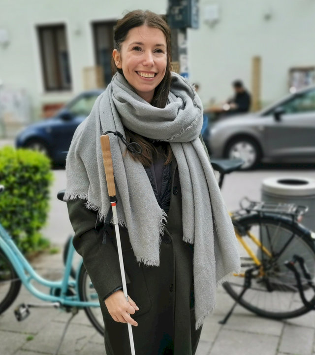 "einfach Mensch: Ich gehe meinen Weg": Anna Garbe auf der Straße. Sie hält ihren Blindenstock in der Hand und lächelt selbstbewusst in die Kamera.