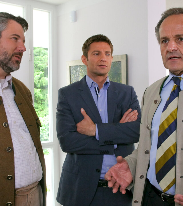 "Die Rosenheim-Cops - Die letzte Beichte": Im Haus an der Eingangstür stehen die Kommissare Anton Stadler (Dieter Fischer) und Sven Hansen (Igor Jeftic) mit Franz Gabelsberger (Stephan Paryla-Raky) und reden.
