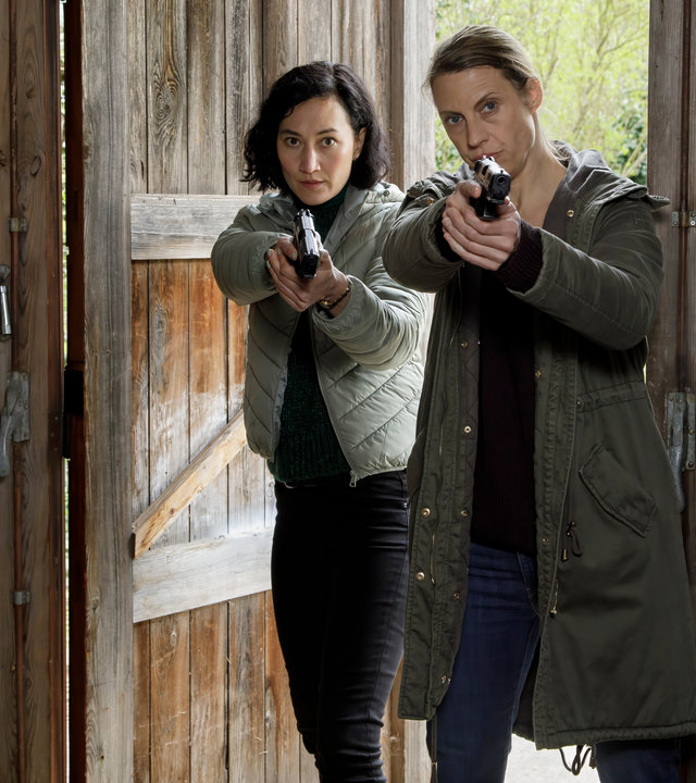 "SOKO Potsdam - Enkeltrick": Pauline Hobrecht (Agnes Decker) und Tamara Meurer (Anja Pahl) stehen mit gezogenen Waffen nebeneinander in einer Garagentür.