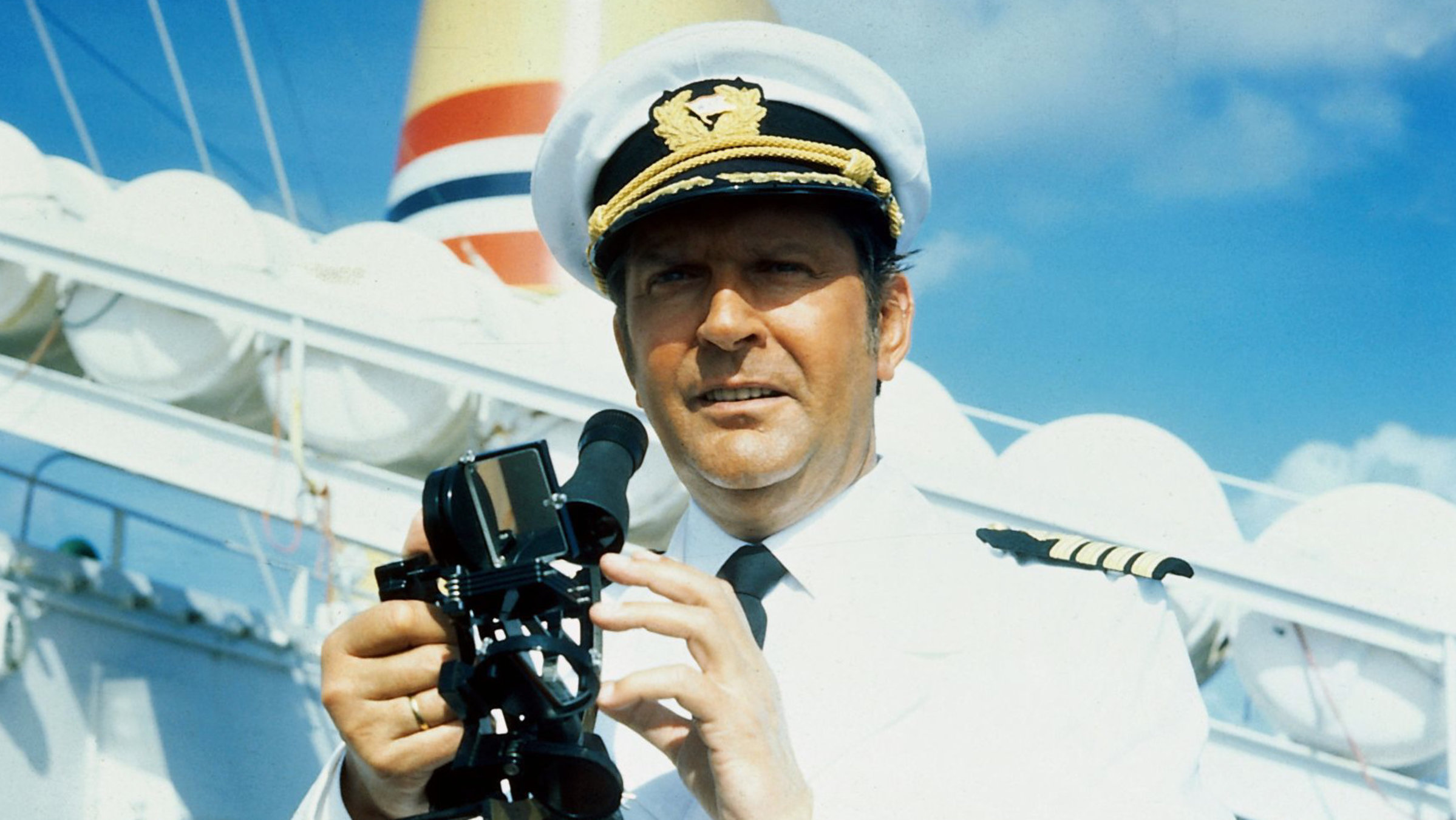 "Das Traumschiff - Die erste Reise: Karibik": Kapitän Braake (Günter König) steht auf dem Traumschiff und hält einen Sextant in der Hand.