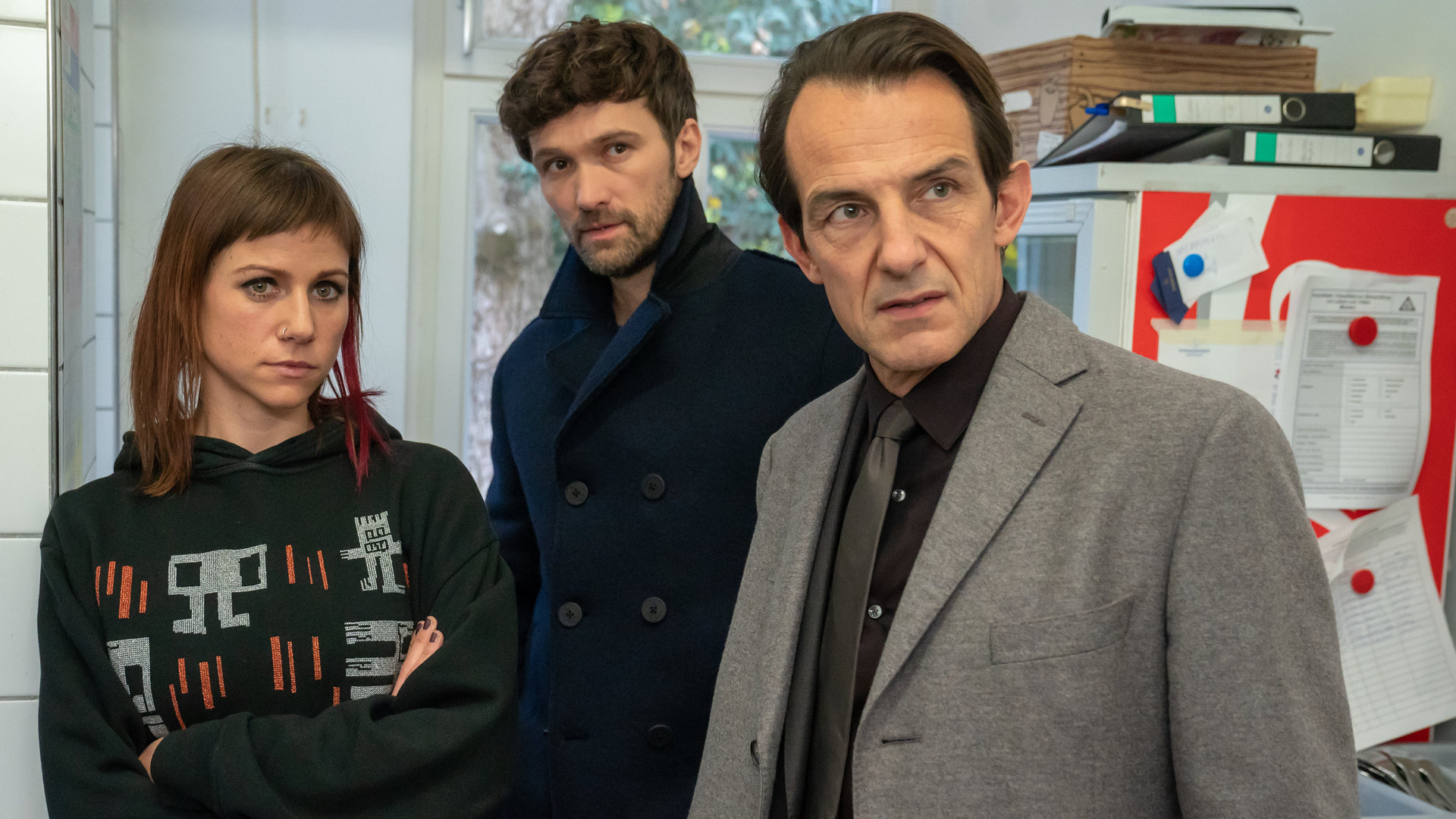 "Letzte Spur Berlin - Urvertrauen": Jules Romberg (Katrin Heß), Alex von Tal (Aleksandar Radenkovic) und Oliver Radek (Hans-Werner Meyer) stehen dicht beieinander in einem Raum. Alle blicken in eine Richtung.