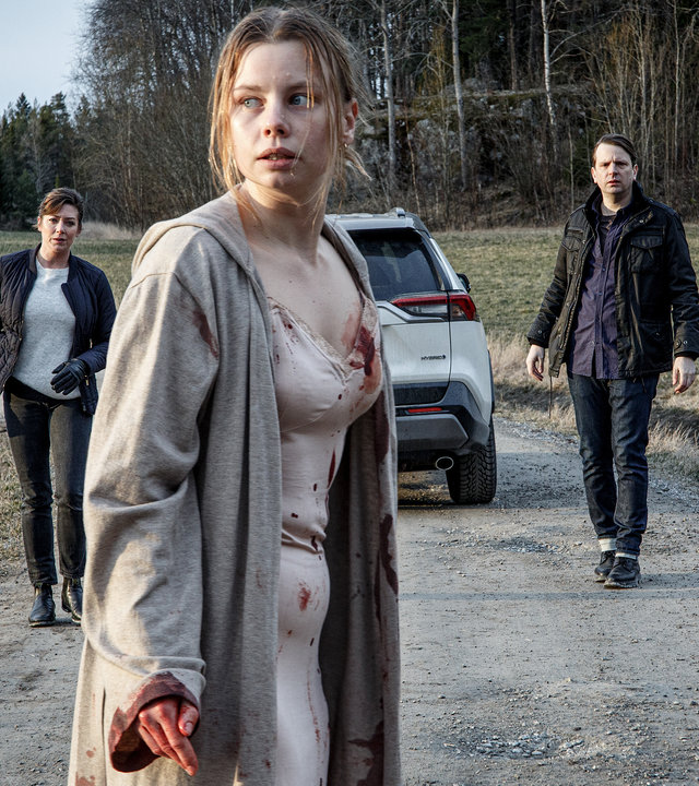 "Kommissar Beck - Ohne jeden Zweifel": Leichtbekleidet und blutverschmiert steht Ida Lind (Amanda Jansson) mitten auf einem Feldweg und blickt panisch um sich. Alexandra Beijer (Jennie Silfverhjelm) und Oskar Bergman (Måns Nathanaelsson) sind aus dem Auto ausgestiegen und nähern sich ihr vorsichtig.