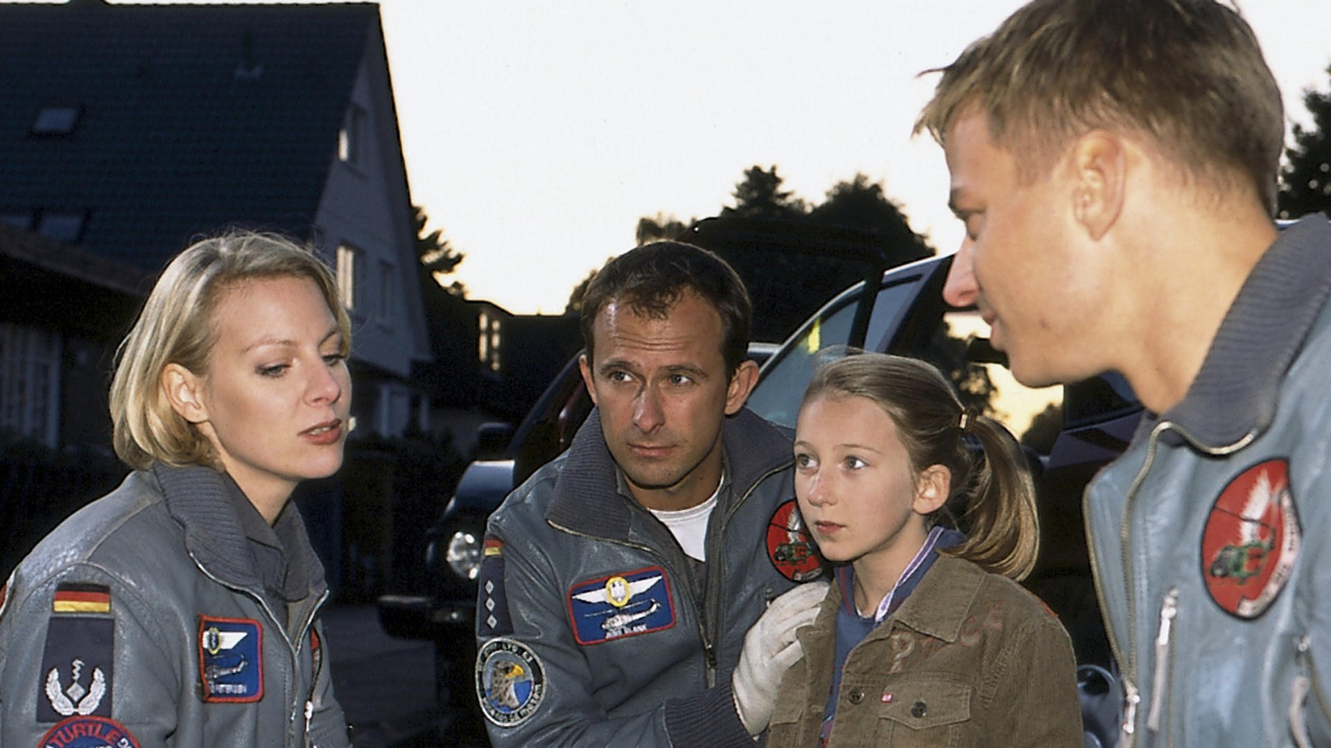 "Die Rettungsflieger - Königskinder": Die Rettungsflieger Sabine (Marlene Marlow), Jens (Nicolas König) und Torsten (Tom Wlaschiha) knien am Boden vor Autos. Zwischen ihnen hockt Mia (Hazel Franke).