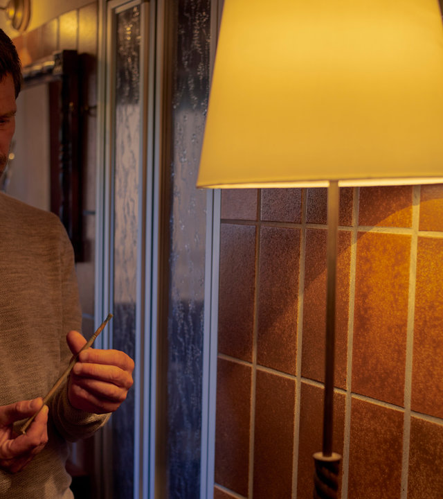 "SOKO Wien - Gefährliche Einkehr": Im Hausflur steht Klaus Lechner (Andreas Kiendl). Neben ihm steht eine Stehlampe. Diese leuchtet auf den Pinsel, den Klaus Lechner in den Händen hält.