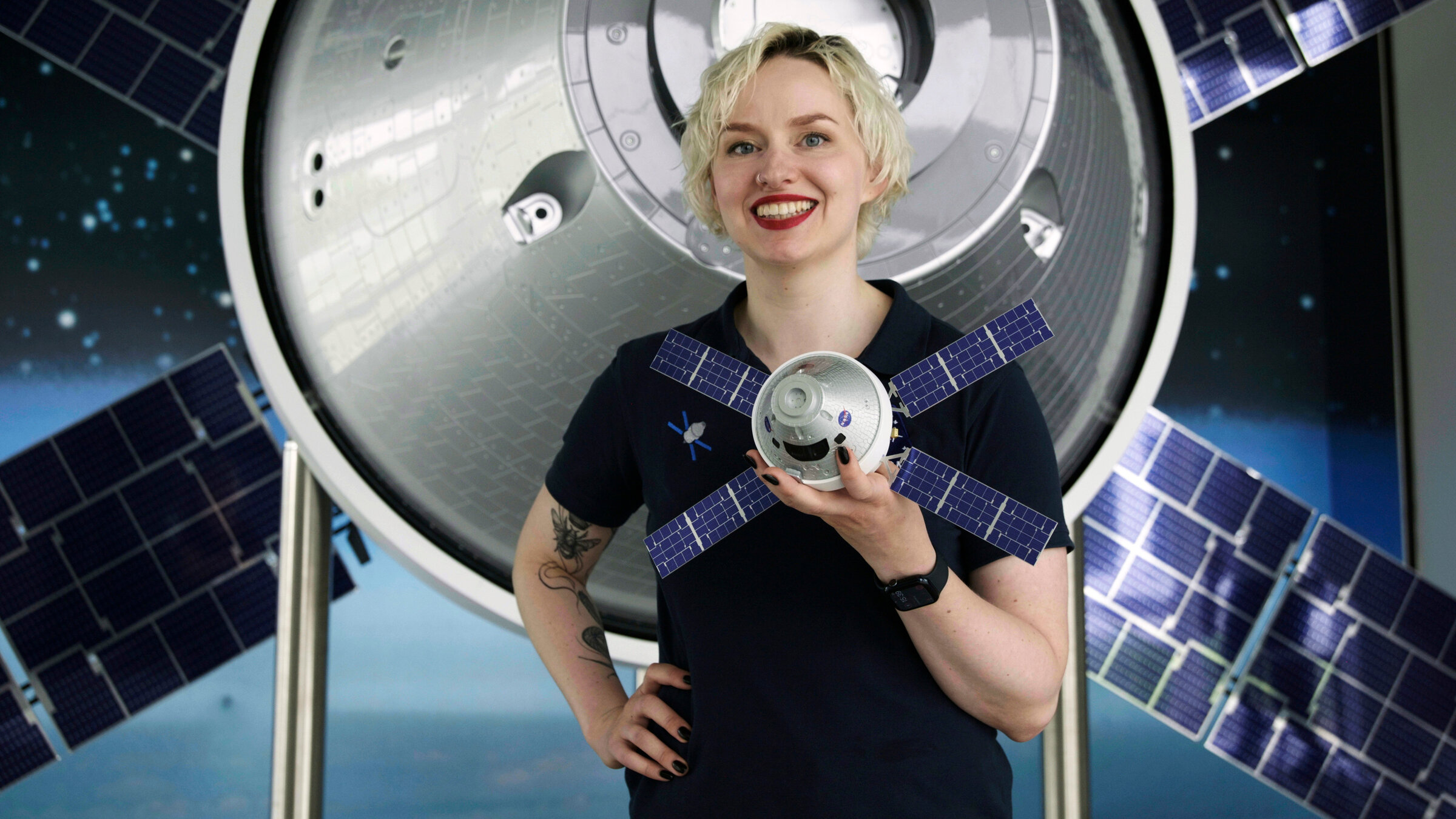 "NANO: Artemis 2 - Zurück zum Mond": Raumfahrtingenieurin Annemarie Lohse vor einem Modell des Orion-Raumschiffs. Bei Airbus in Bremen wird ein entscheidendes Bauteil gefertigt - das für die AstronautInnen überlebenswichtige Europäische Service Modul (ESM).