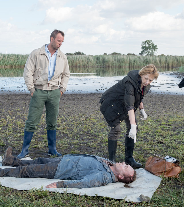"SOKO Wismar – Rote Erna“: Lars Pöhlmann (Dominic Boeer), Helene Sturbeck (Katharina Blaschke), Kai Timmermann (Matthias Junge) und Katrin Börensen (Claudia Schmutzler) inspizieren die Leiche von Paul Gödecke (Thomas Sobotzki), die auf einer Plane im Feld liegt.