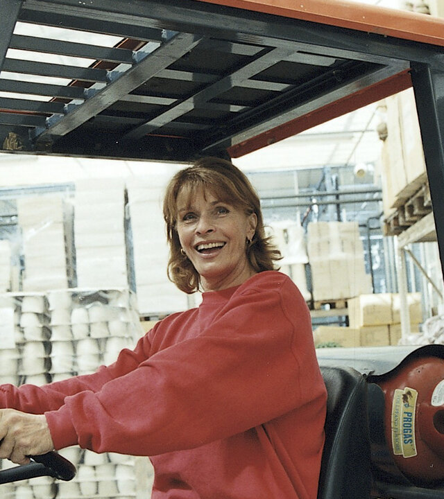 "Die schnelle Gerdi und die Hauptstadt – Die München-Connection": Gerdi (Senta Berger) sitzt lachend am Steuer eines Gabelstaplers in einem Dekogeschäft.