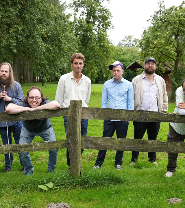 "einfach Mensch - Inklusion rockt: Die Band "Station 17": Die Band "Station 17": Hauke Röh, Sebastian Stuber, Ernesto Schnettler, Philipp Wulf, Christian Fleck, Nils Kempen und Siyavash Gharibi auf einer grünen Wiese.