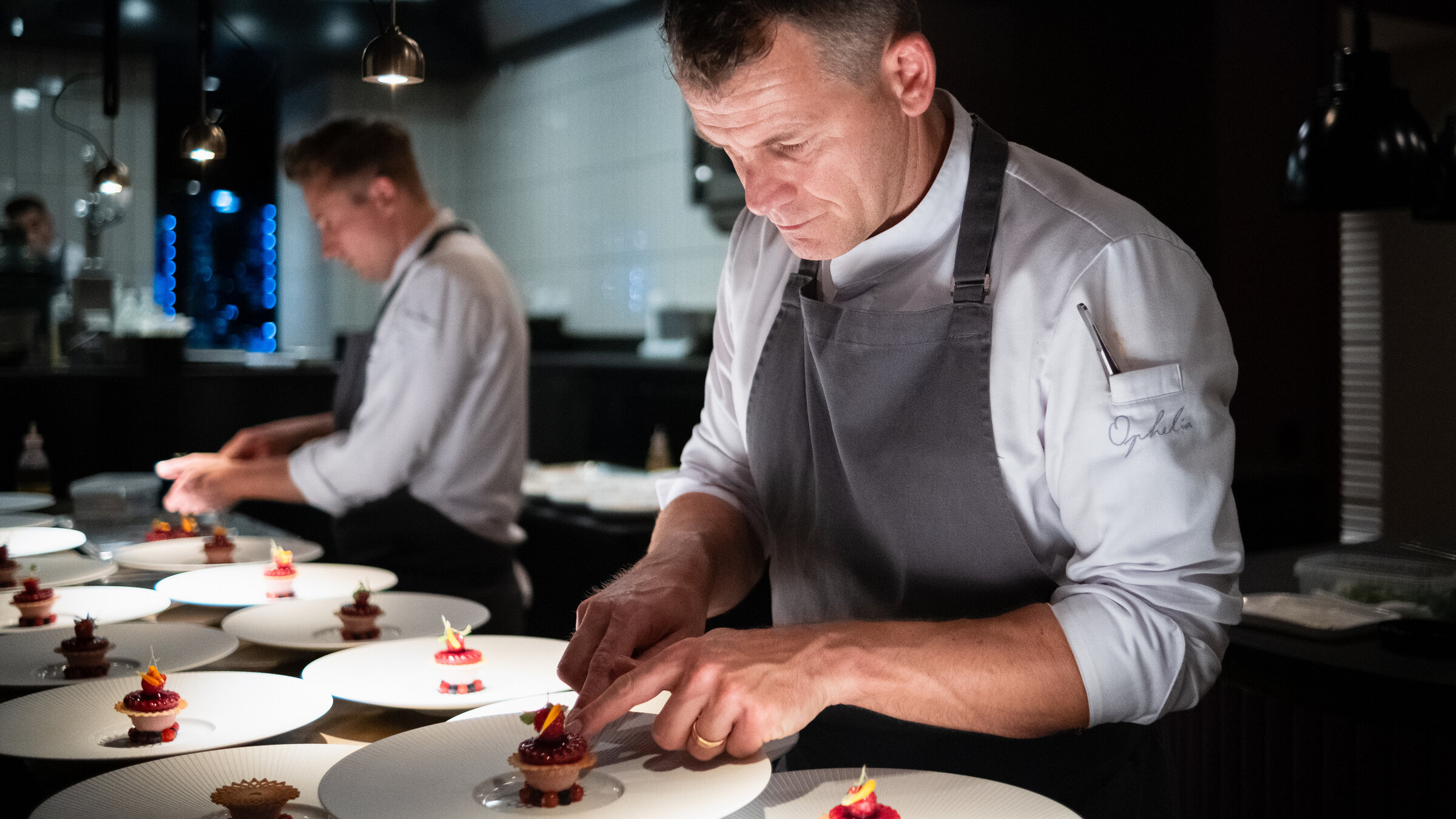 "Am Pass - Geschichten aus der Spitzenküche - Dirk Hoberg, Konstanz": Dirk Hoberg (re.), Küchenchef des Gourmetrestaurants Ophelia in Konstanz, stellt sich der Herausforderung einer offenen Küche. Die Gäste können jeden Handgriff, jedes Wort verfolgen, was die Teamarbeit umso wichtiger macht.
